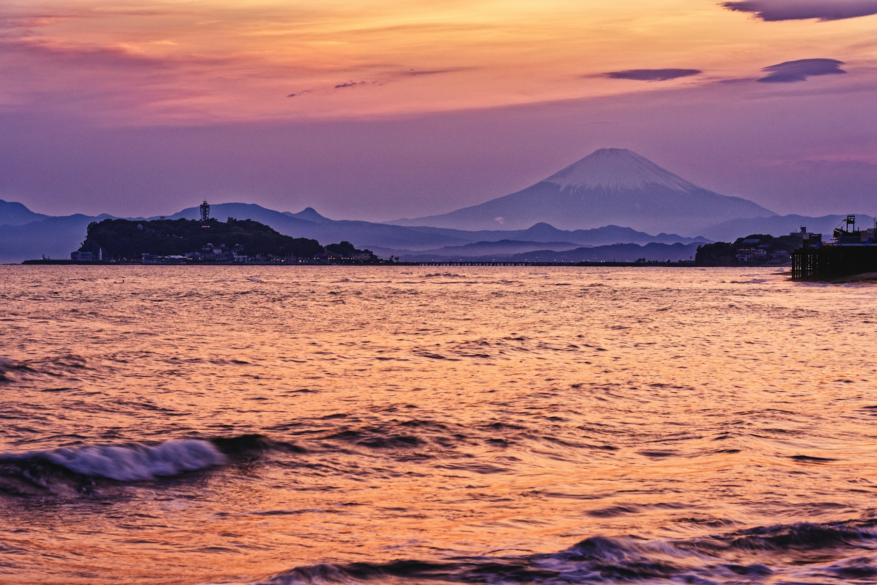 Sunset light across the sea with Mount Fuji on the horizon